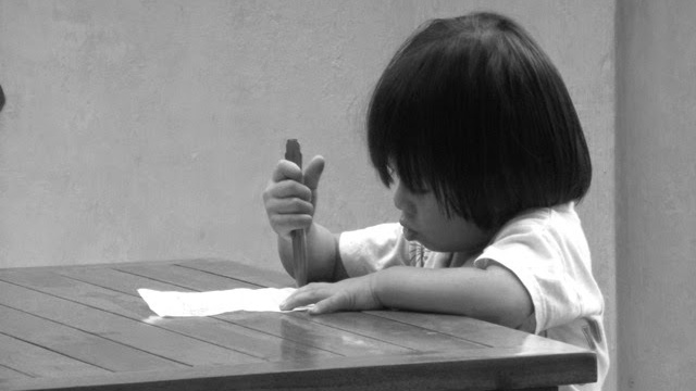 Indonéská holčička píše příběhy.